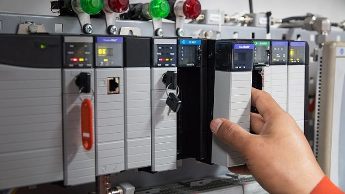 Tech removing a PLC module from a chassis slot